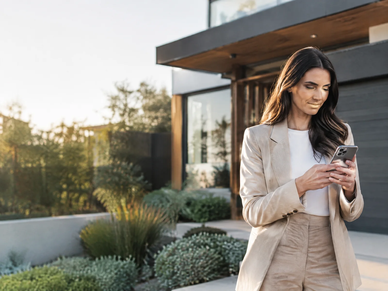 Real estate professional reviewing a property enquiry outside a modern home